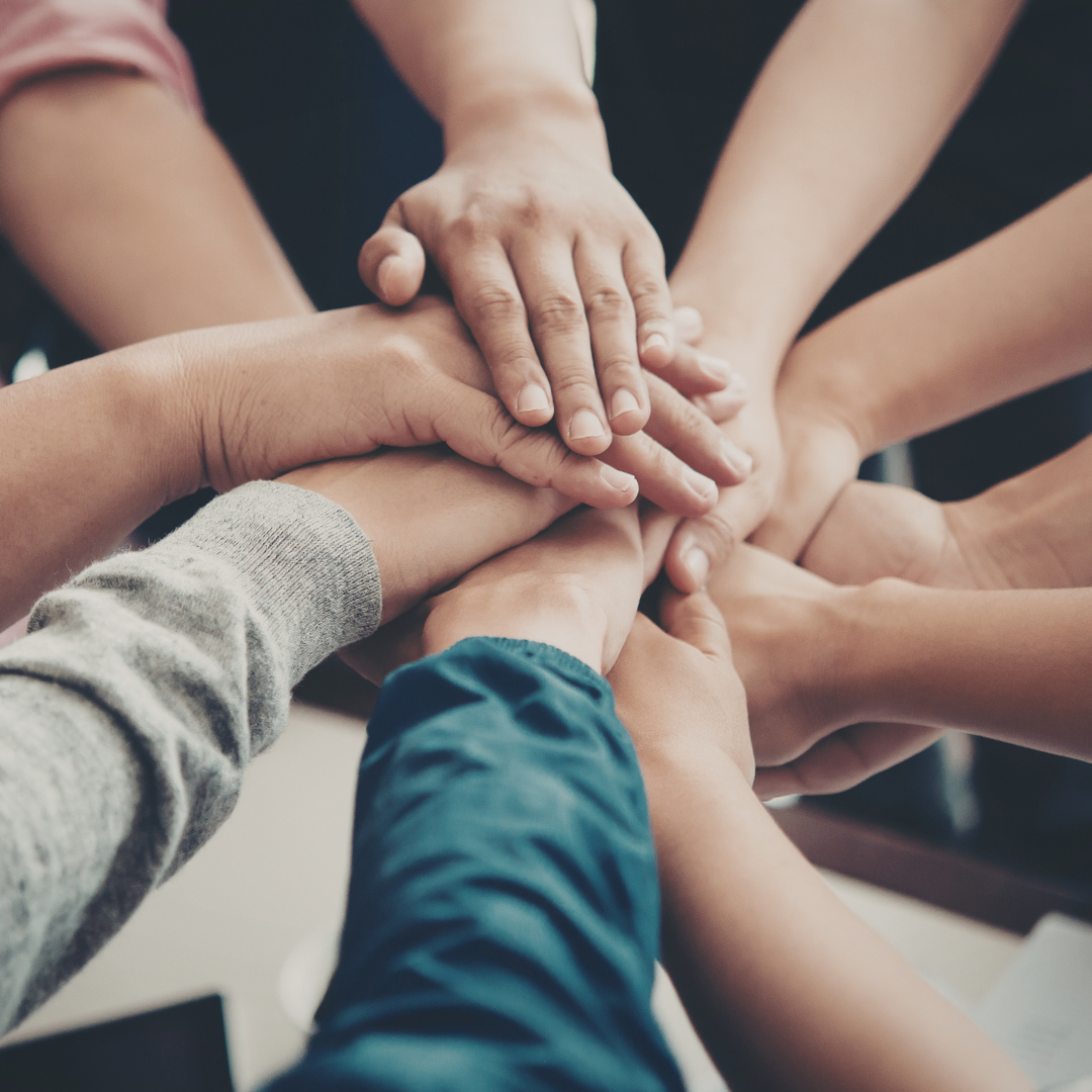 Group of people stacking their hands together